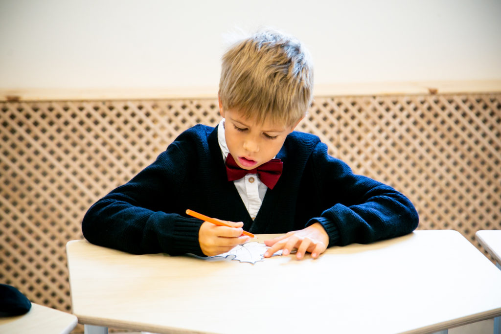 ребенок пишет на листке бумаги